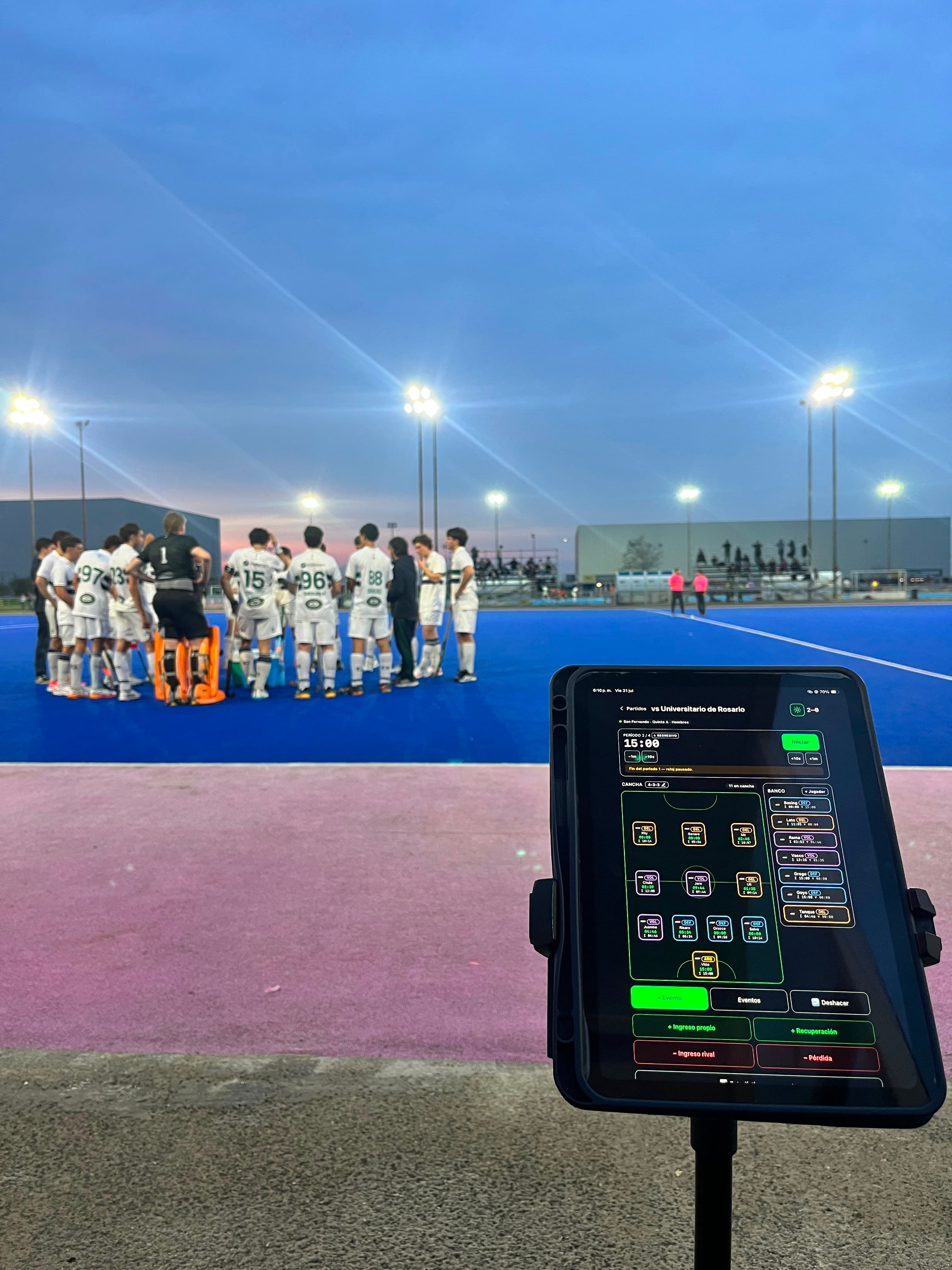 Vision Hockey registrando un partido desde una tablet al borde de una cancha de hockey sobre césped